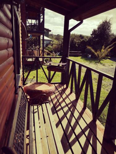 a wooden deck with a bench on a porch at Cabañas Kompatzki in Ancud
