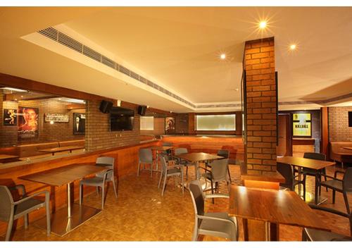 a restaurant with tables and chairs in a room at Jk Park Residency Perambra in Mennānyam