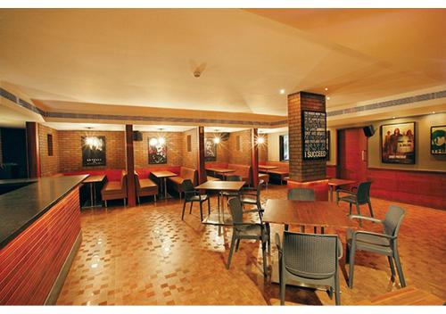 a restaurant with tables and chairs and a bar at Jk Park Residency Perambra in Mennānyam