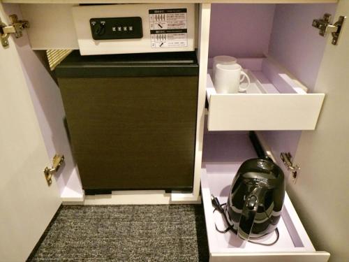 a kitchen with a coffee maker in a cabinet at Henn na Hotel Tokyo Ginza in Tokyo
