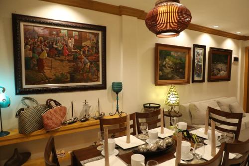 a dining room with a table and a painting on the wall at Stay Amare Bayswater Mactan in Mactan