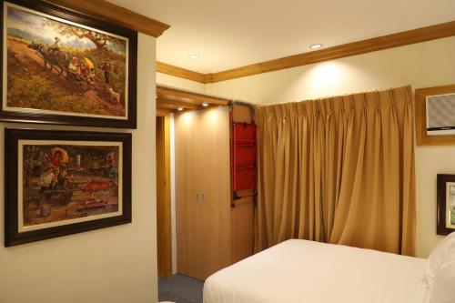 a bedroom with a bed and a painting on the wall at Stay Amare Bayswater Mactan in Mactan