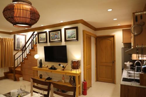 a living room with a television and a staircase at Stay Amare Bayswater Mactan in Mactan