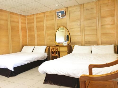 2 łóżka w pokoju z lustrem w obiekcie Xianshan Homestay w mieście Shitan