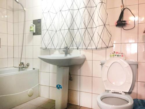 une salle de bain avec toilettes et lavabo dans l'établissement Xianshan Homestay, à Shitan