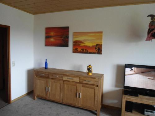a living room with a tv and a wooden cabinet at Haus Fernblick in Bad Grund