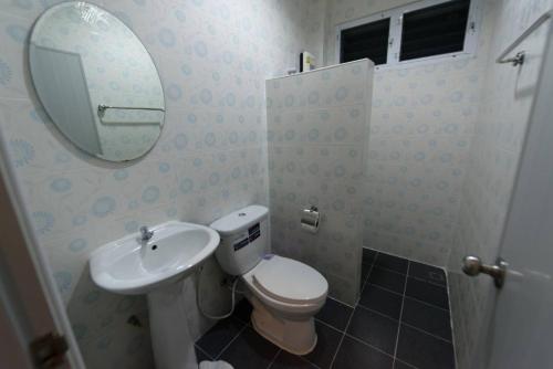 ein Badezimmer mit einem WC, einem Waschbecken und einem Spiegel in der Unterkunft Kanlaya Place in Chiang Rai