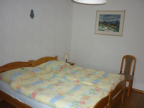 a bedroom with a bed with a quilt on it at La Caquerelle in Col des Rangiers