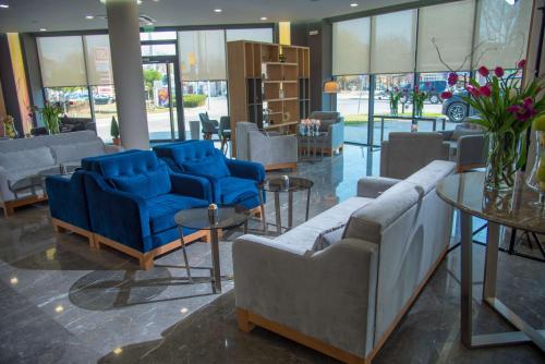 a lobby with blue chairs and tables and windows at Best Western Premier Plovdiv Hills in Plovdiv