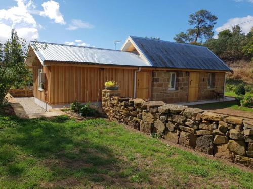 a log cabin with a stone wall at Rosendale Stables in New Norfolk