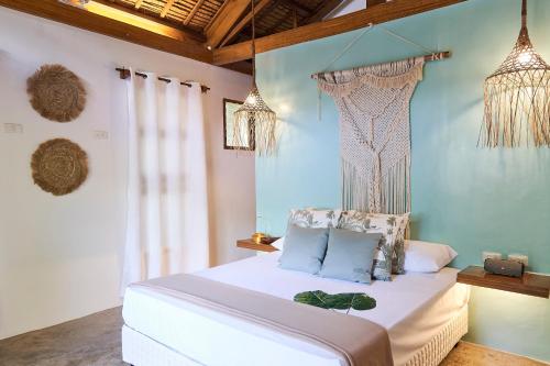 Schlafzimmer mit einem Bett mit blauen Wänden und Kronleuchtern in der Unterkunft G Villas Siargao in General Luna