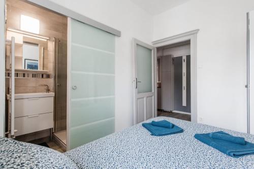 1 dormitorio con 1 cama con 2 toallas azules en Kincsem Budapest Apartman, en Budapest