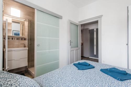 ブダペストにあるKincsem Budapest Apartmanのベッドルーム1室(青いタオル2枚付)