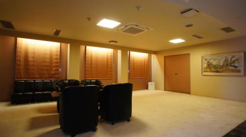 a room with chairs and a table and a painting at Hotel Free Style in Kofu