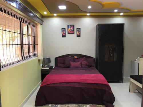 a bedroom with a bed with a purple blanket at Safe Home Stay in Cansaulim