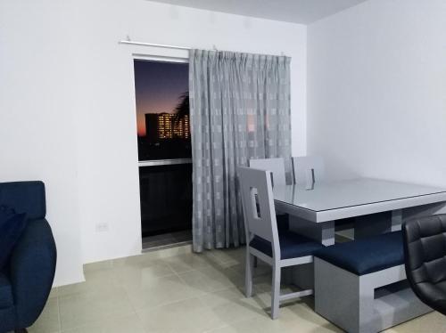 comedor con mesa, sillas y ventana en Cerritos Apartamento en Mazatlán