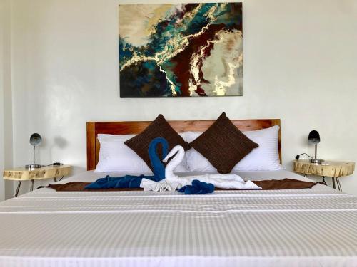 a bedroom with a bed with towels and swans on it at Sunset Cove Beach & Dive Resort in Romblon