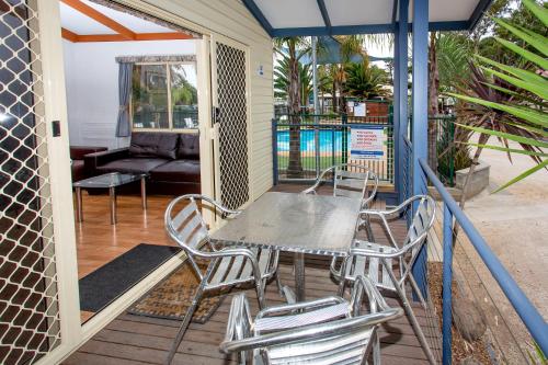 a patio area with chairs, tables, and umbrellas at Ingenia Holidays Torquay Australia in Torquay