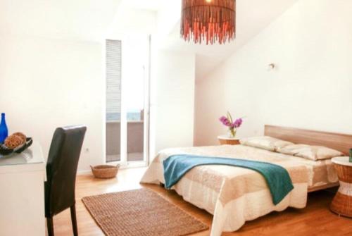 a bedroom with a bed and a table and a window at Penthouse Apartments Ana in Sutivan