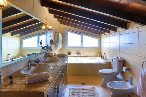 a bathroom with two sinks and a tub and a toilet at Villa Dimeli in Barbati