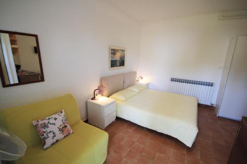 a bedroom with a white bed and a yellow couch at Mira Apartments in Novigrad Istria