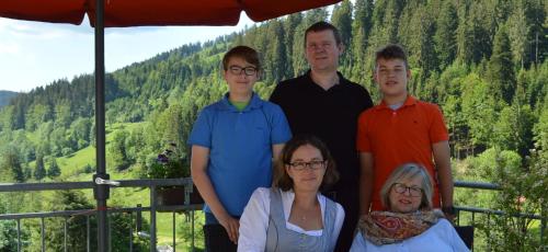 a family posing for a picture in front of a mountain at Landhaus Eickler in Baiersbronn