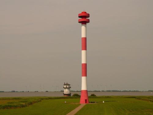 a lighthouse with a red and white pole in a field at Rauszeit-Balje in Balje