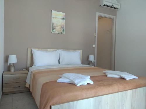 a bedroom with a large bed with two pillows on it at Egrypos Hotel in Petrití