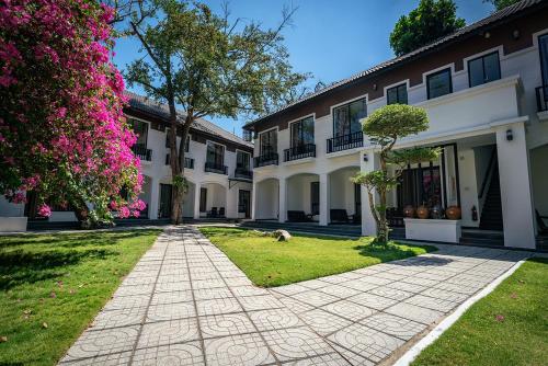 a courtyard of a house with pink flowers at Ven Ven Hotel in Ho Coc