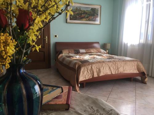 a bedroom with a bed and a vase of flowers at Villa Giulia in Avezzano