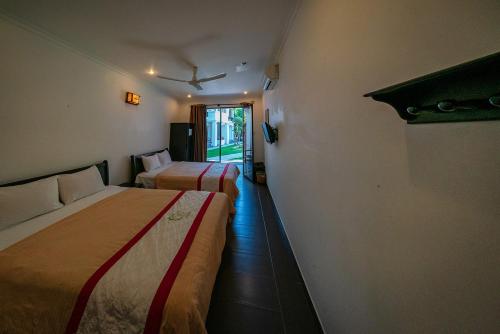 a hotel room with two beds and a window at Ven Ven Hotel in Ho Coc