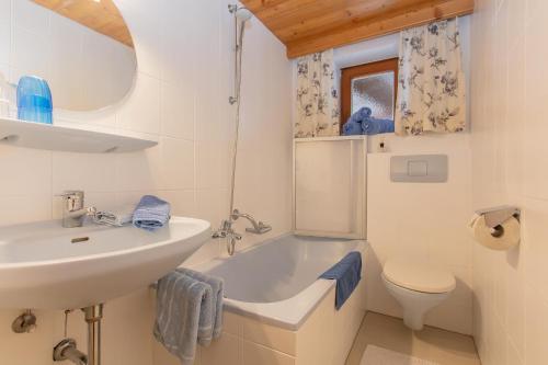 ein Badezimmer mit einem Waschbecken, einer Badewanne und einem WC in der Unterkunft Gästehaus Rosi in Fieberbrunn