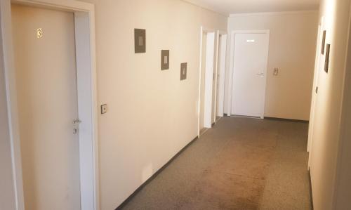 an empty corridor with white walls and a hallway with doors at Gasthof L'italiano Vero in Bad Liebenzell
