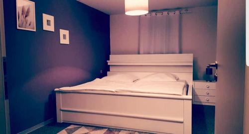 a bedroom with a white bed with a blue wall at Gasthof L'italiano Vero in Bad Liebenzell