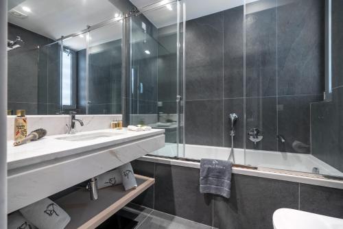 a bathroom with a sink, toilet and bathtub at Glyfada Riviera Hotel in Athens