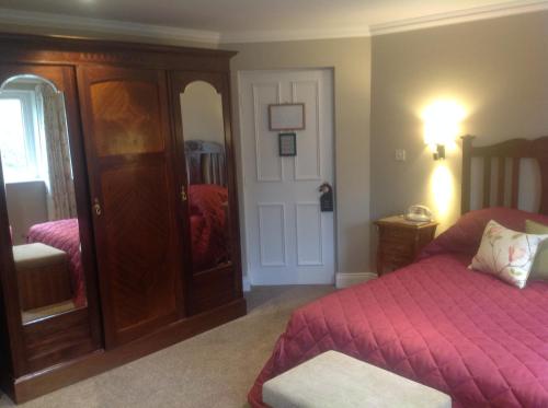 
a bedroom with a bed and a dresser at Gleann Fia Country House in Killarney
