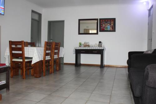 a living room with a table and a dining room at Strand Meadows B&B in Gaborone