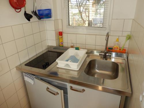 eine kleine Küche mit einer Spüle und einer Arbeitsplatte in der Unterkunft Bungalow (hälfte) Steuerbord Ahlbeck (Usedom) in Ahlbeck
