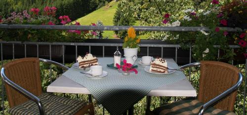 a table with cakes on it with two chairs at Landhaus Eickler in Baiersbronn