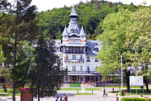 a large white building with a pointed roof at Hotel Central in Călimăneşti