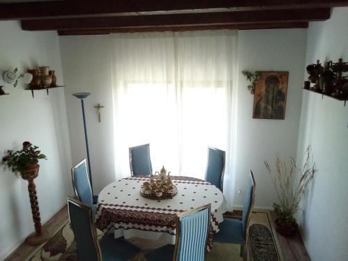 a dining room with a table and chairs and a window at Pensiunea La Poarta Bucovinei in Suceava
