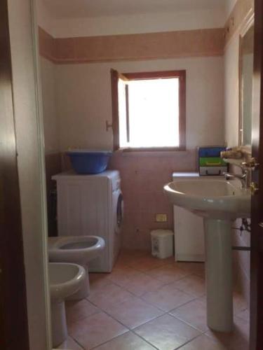 a bathroom with a sink and a toilet and a window at Honey's little house in Palau