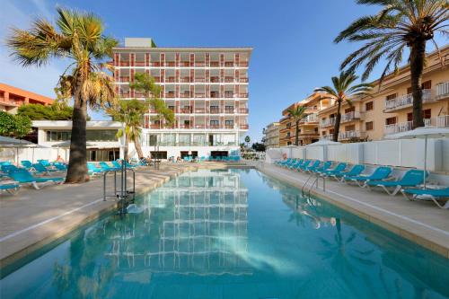 una piscina con sillas y un hotel en Talayot - Adults Only en Cala Millor