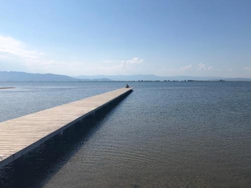 a person sitting on a dock in the water at Albergue Delta in L'Eucaliptus