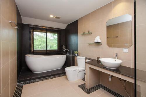 a bathroom with a tub and a toilet and a sink at Baan Santhiya Private Pool Villas - FREE Tuk-Tuk Service to the Beach! in Ao Nang Beach