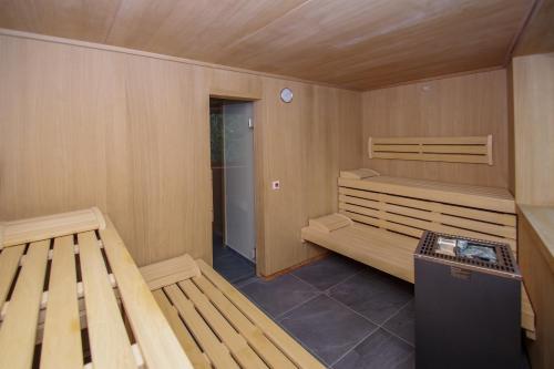 a sauna with two wooden benches in a room at Apartment Hotel Christine in Avelengo