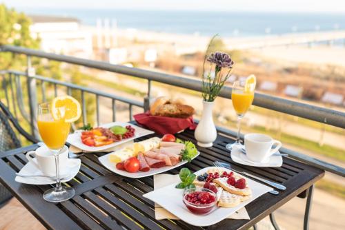 a table with two plates of food and two glasses of orange juice at Strandhotel Möwe in Bansin