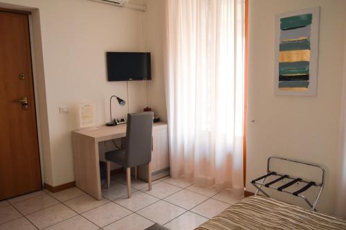 a bedroom with a desk with a computer and a bed at La Contrada in Sarnico