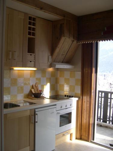 une cuisine avec un évier et une cuisinière four supérieur dans l'établissement Studio Les Drus / Studio du Brévent, à Chamonix-Mont-Blanc