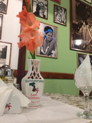 a vase sitting on a table with a flower in it at Pensiunea San Gennaro in Miercurea-Ciuc